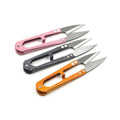Three multicolored sewing snip scissors with sharp blades arranged diagonally on a white background.
