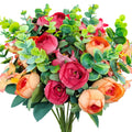 Artificial bouquet of red and orange roses with eucalyptus leaves on a white background
