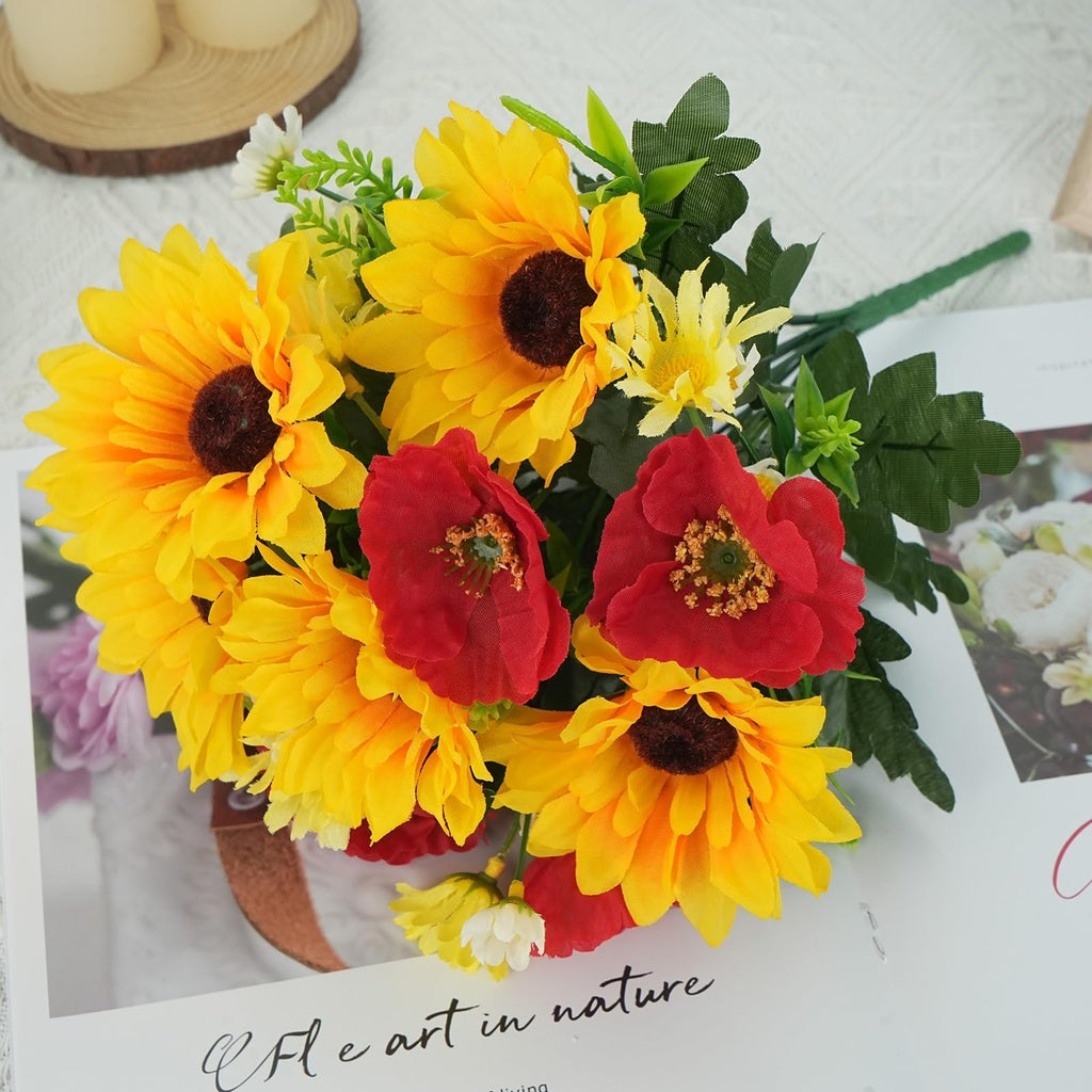 Bouquet of faux sunflowers and red poppies with green leaves on a white surface with text