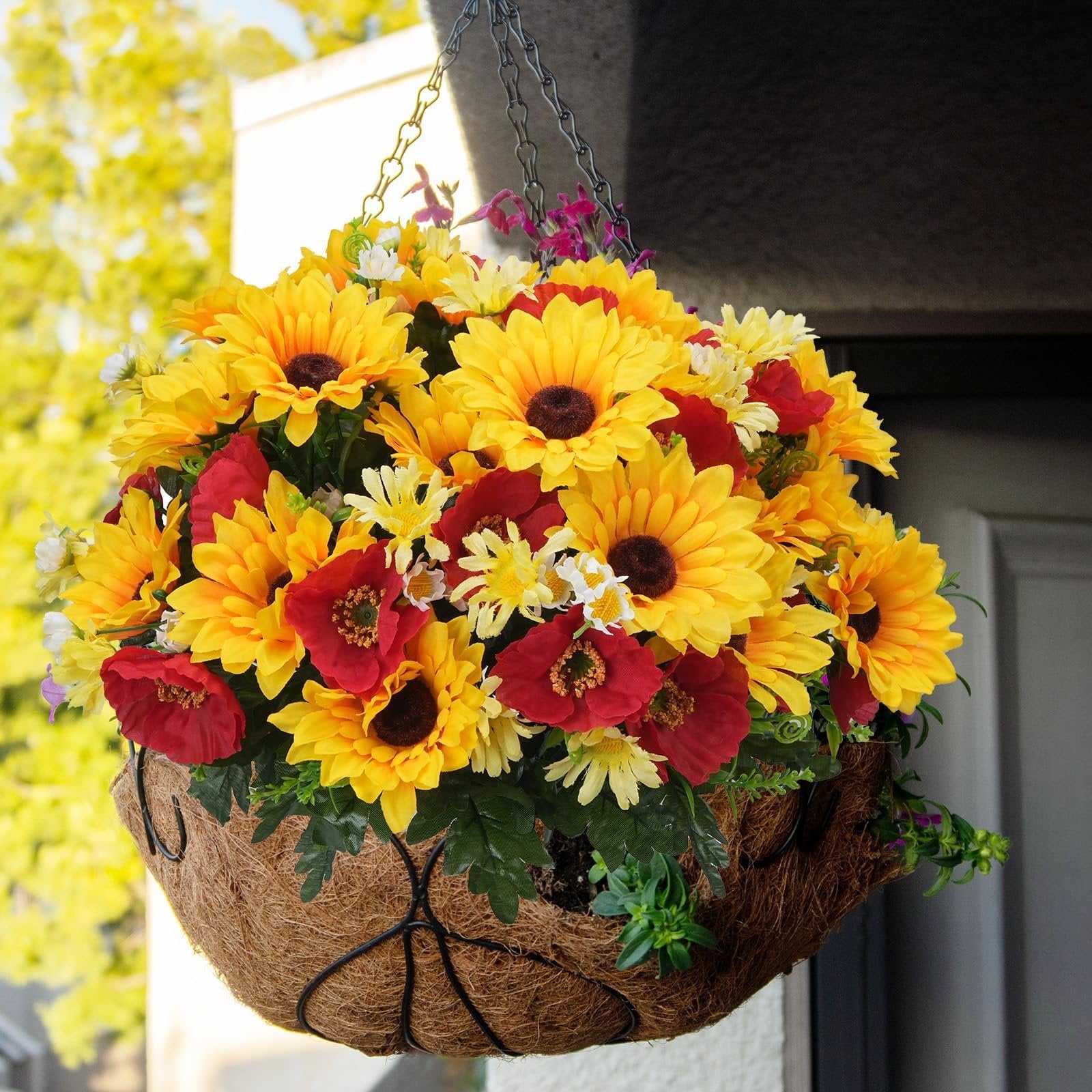 Hanging basket filled with faux sunflowers, daisies, and poppies, with green foliage.