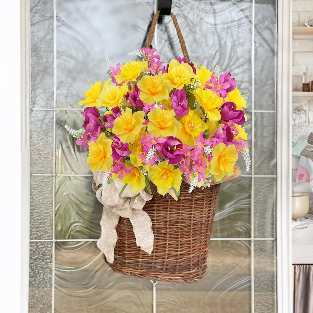 Wicker basket filled with artificial daffodils and tulips, tied with a burlap bow, hanging on a glass door.