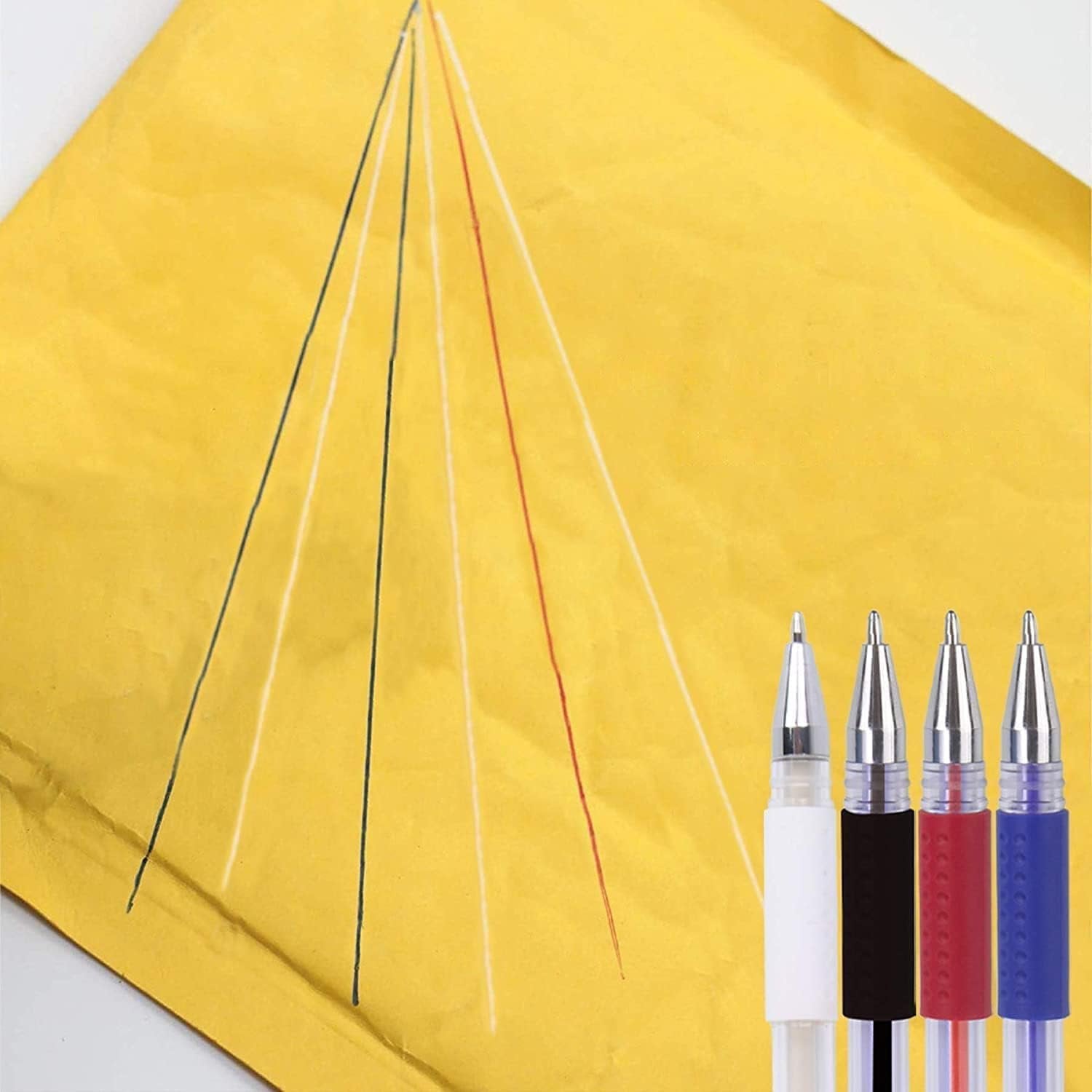 Four heat erasable fabric marking pens in white, black, red, and blue, with lines drawn on yellow fabric.