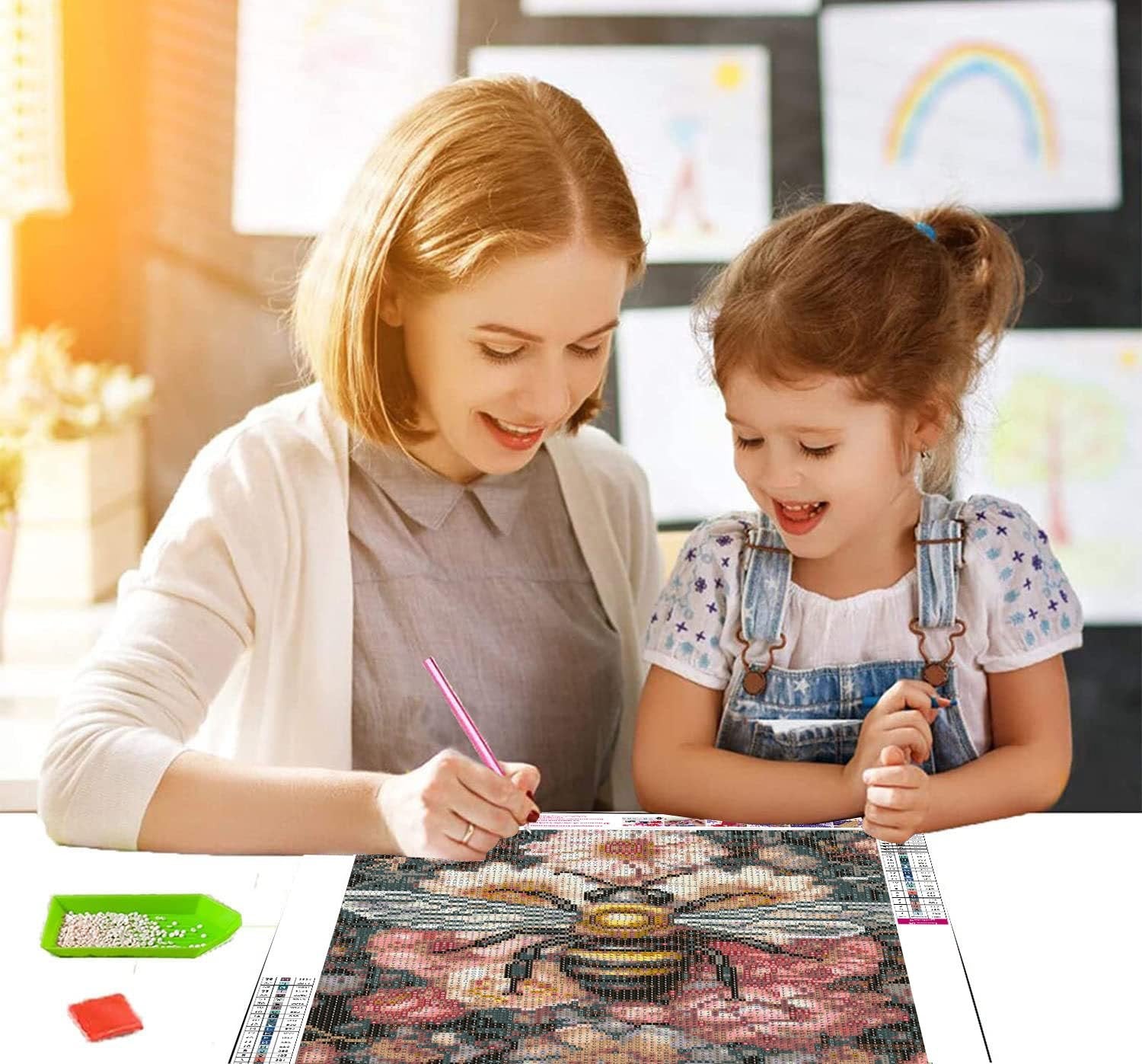 Woman and child doing a diamond painting kit featuring a bee and flowers