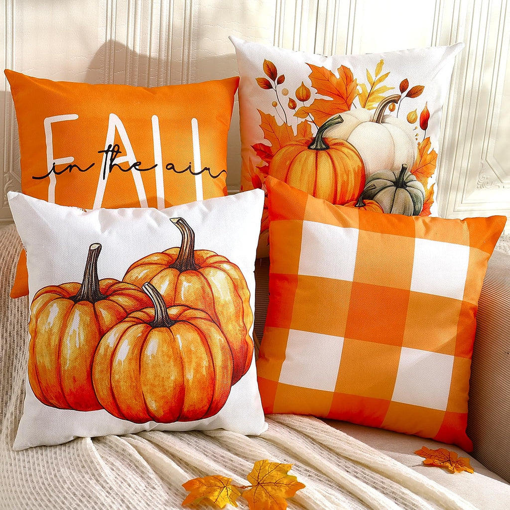 Four fall-themed throw pillow covers arranged on a couch, featuring pumpkins, buffalo plaid, and text.