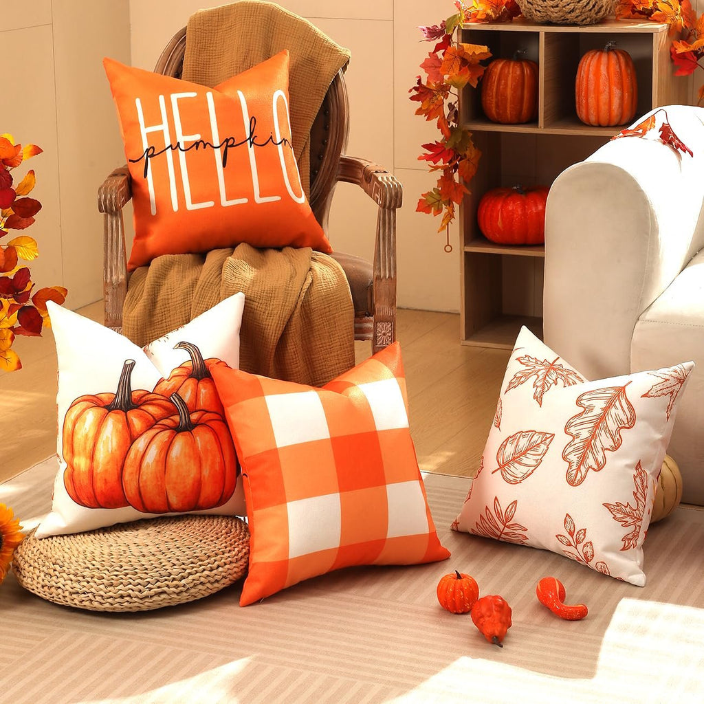 Four fall-themed throw pillow covers arranged in a cozy living room setting with pumpkins and autumn leaves decor.