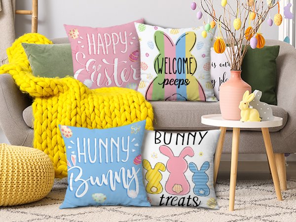 Four Easter-themed throw pillow covers with bunny and egg designs arranged on a sofa and side table.