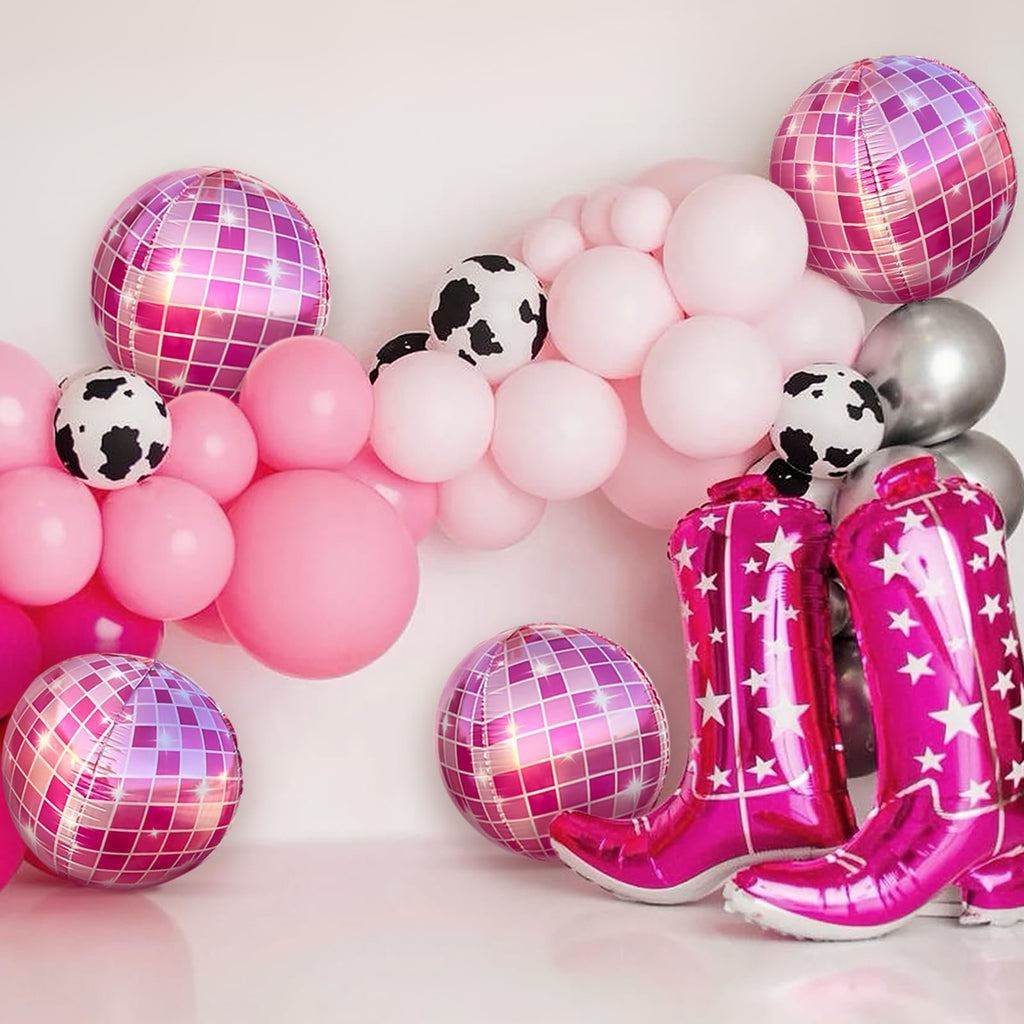 Pink disco ball balloons and cowboy boot balloons arranged for a party backdrop