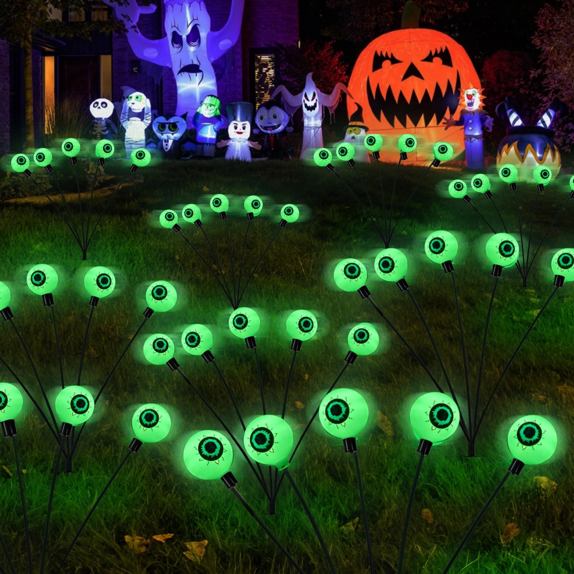 Glowing green eyeball pathway lights in a yard with Halloween inflatables