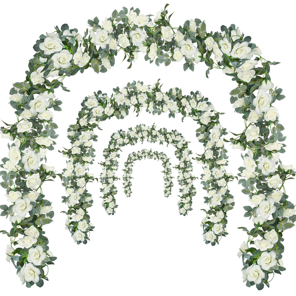 Four cascading artificial rose garlands with white flowers and green leaves arranged in arches on a white background.