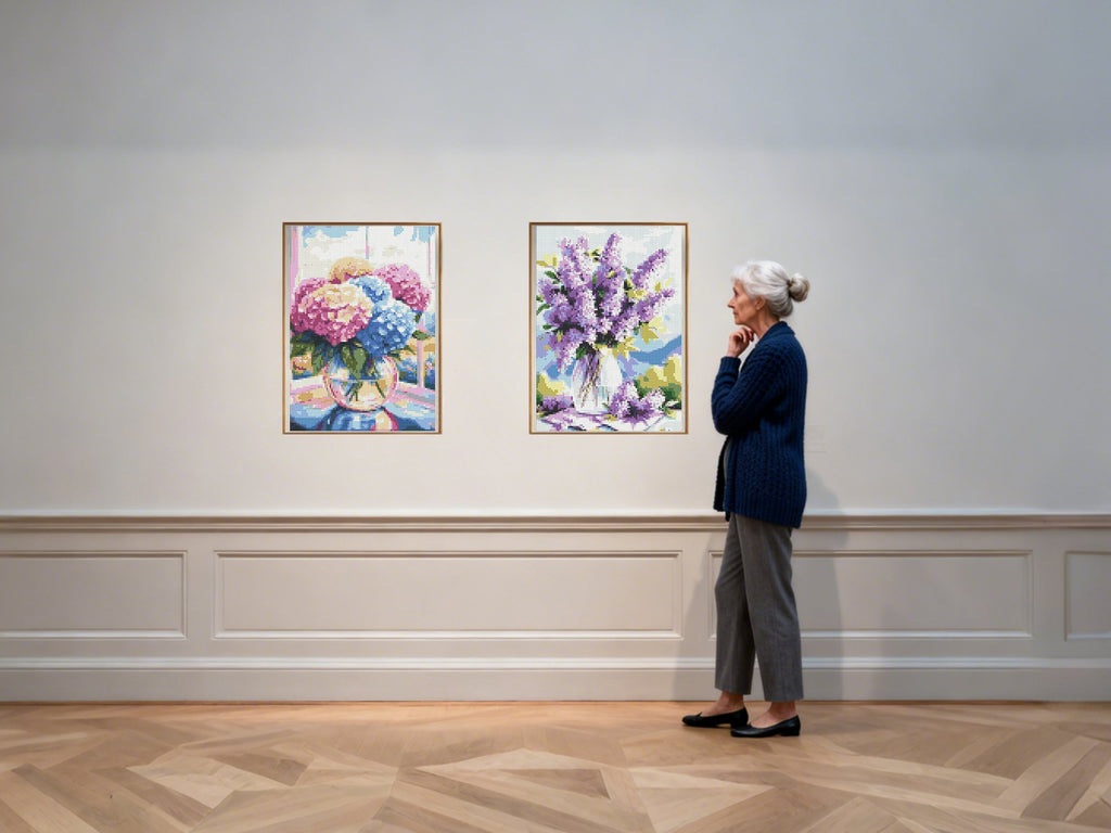 Woman admiring two framed diamond paintings of floral arrangements in a gallery setting