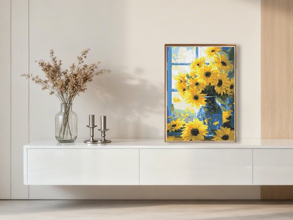 Framed diamond painting of sunflowers in a vase on a shelf with decorative items