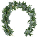 Artificial eucalyptus garland with round and pointed green leaves arranged on a white background