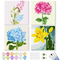 Four framed paint by number kits featuring floral designs: pink and blue flowers, pink hydrangea, blue hydrangea, and yellow lily in a vase.