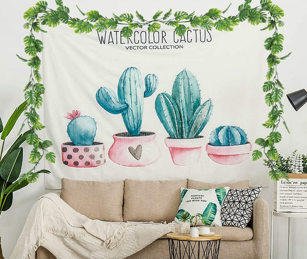 Artificial monstera vines draped around a tapestry featuring watercolor cacti in pots above a sofa.