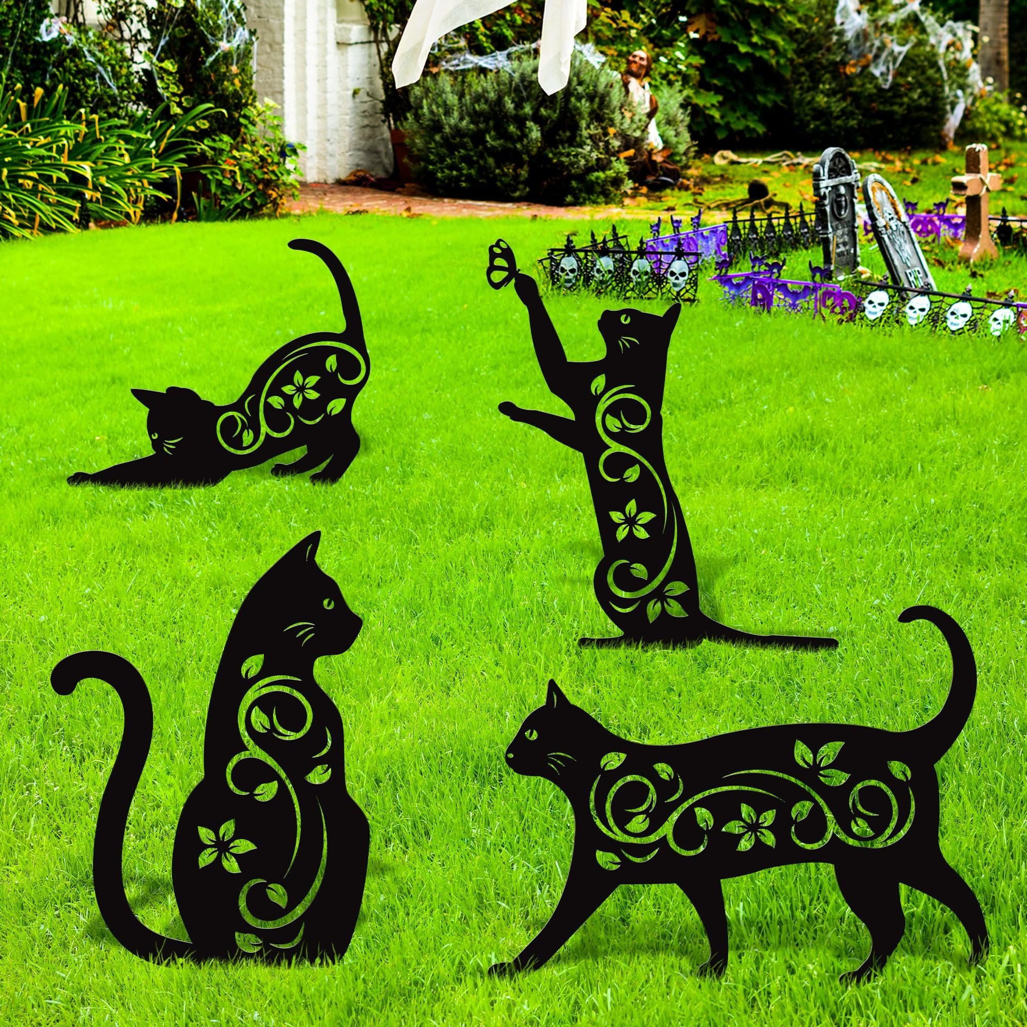 Four black metal cat silhouette garden stakes with vine and flower cutouts on green grass, with Halloween decorations in background.