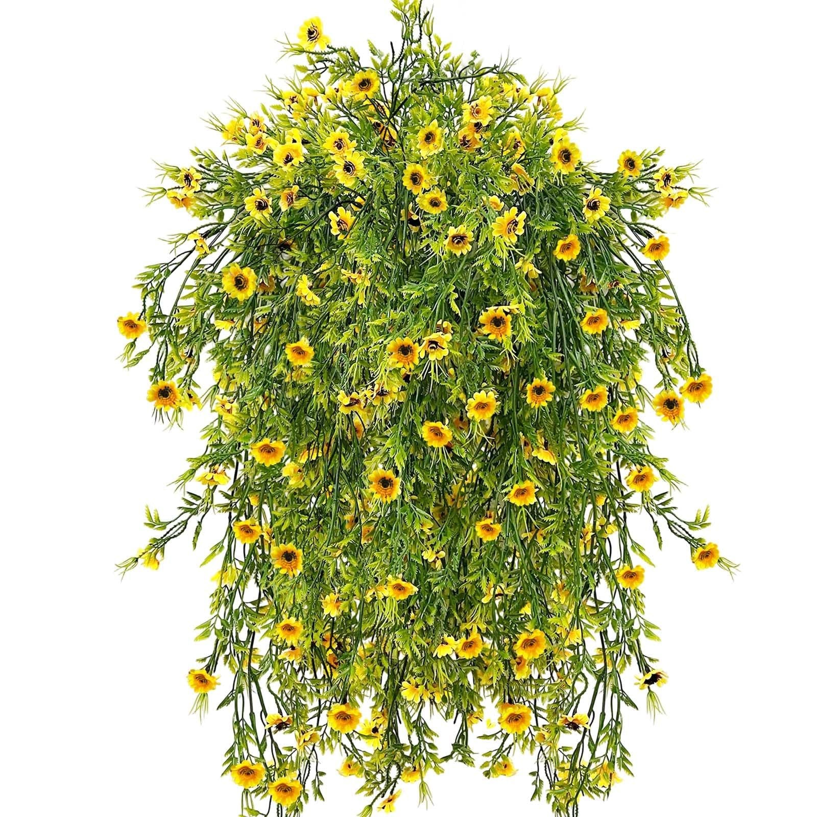 Hanging artificial daisy plant with bright yellow flowers and green foliage, shown from a top-down perspective against a white background.