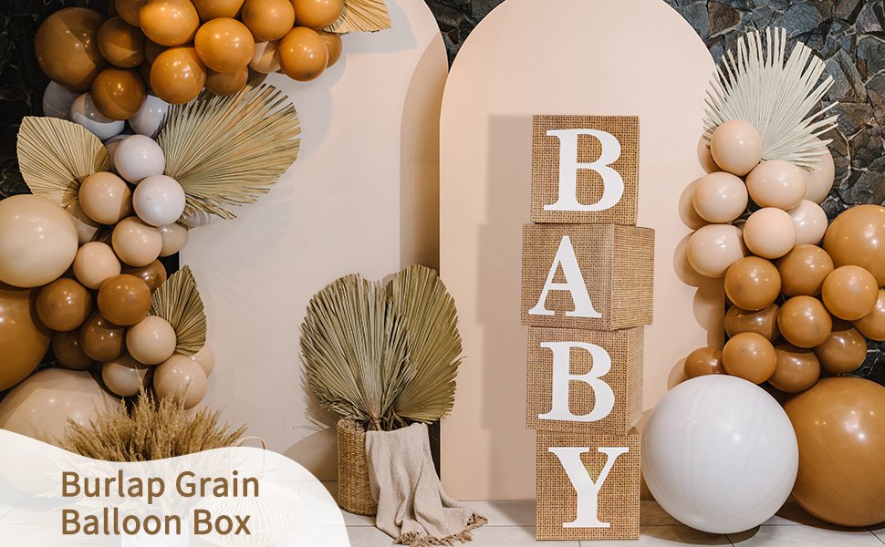 Four burlap boxes stacked to spell BABY, decorated with balloons and dried palm leaves for a baby shower.