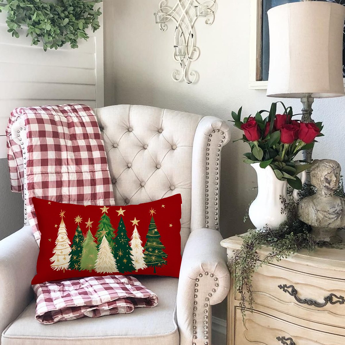Rectangular Christmas pillow cover with red background and assorted green and white Christmas trees with gold stars.