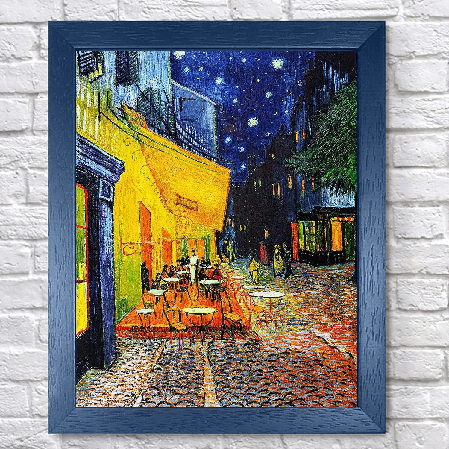 Diamond painting kit featuring Van Gogh's Cafe Terrace at Night, framed in blue, on a white brick background.