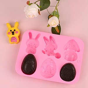 Pink silicone Easter mold with bunny and egg shapes, one yellow bunny candy shown separately.