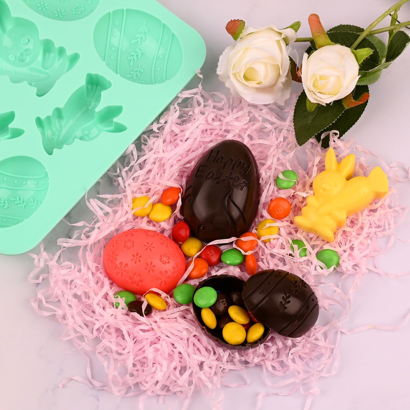 Easter silicone mold with bunnies and eggs, surrounded by chocolate candies and decorative roses.
