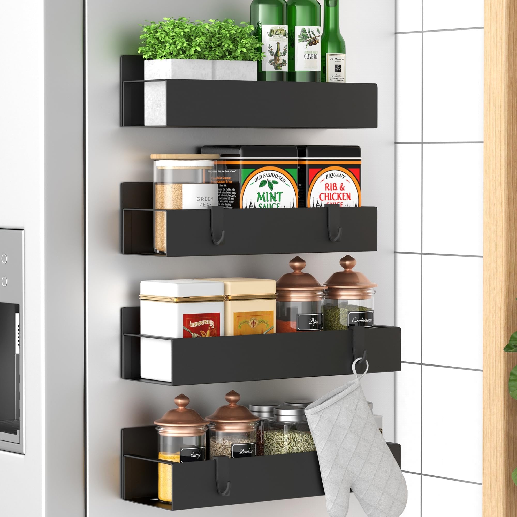 Four black magnetic spice racks mounted on a refrigerator, holding various jars, bottles, and an oven mitt.