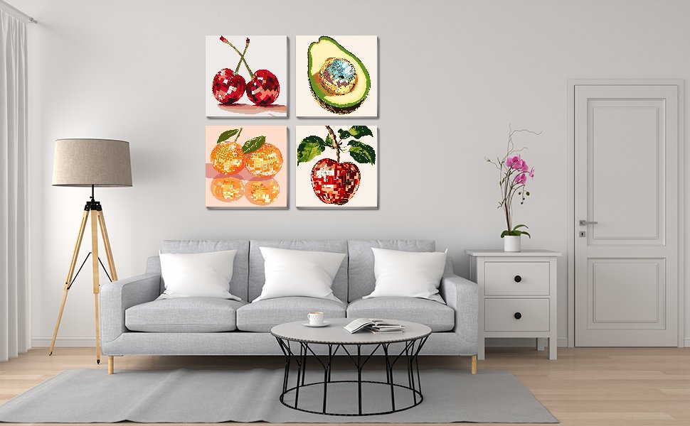 Four framed paint by number canvases depicting fruit arranged on a wall above a sofa.
