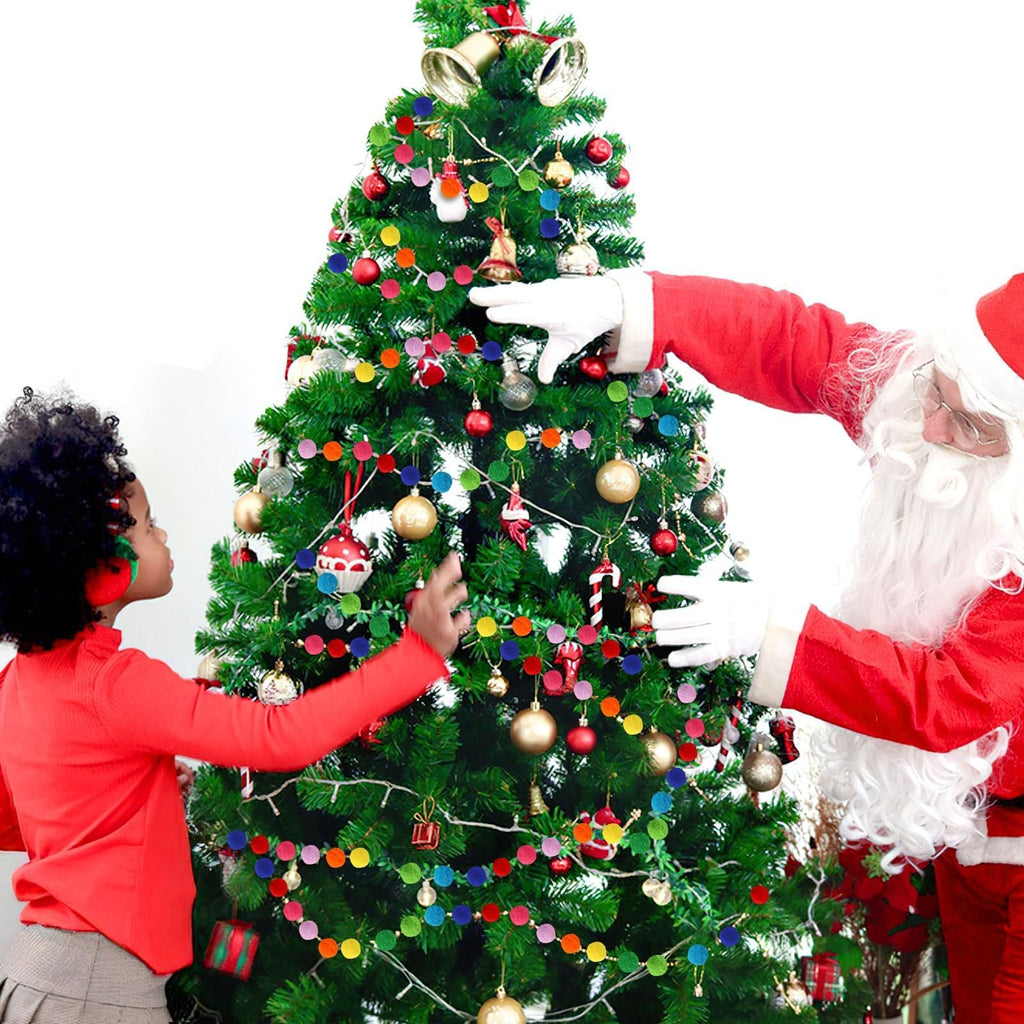 Child and Santa decorating a Christmas tree with rainbow pom pom garlands