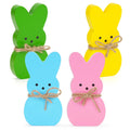 Four pastel wooden Easter bunny decorations with twine bows on white background