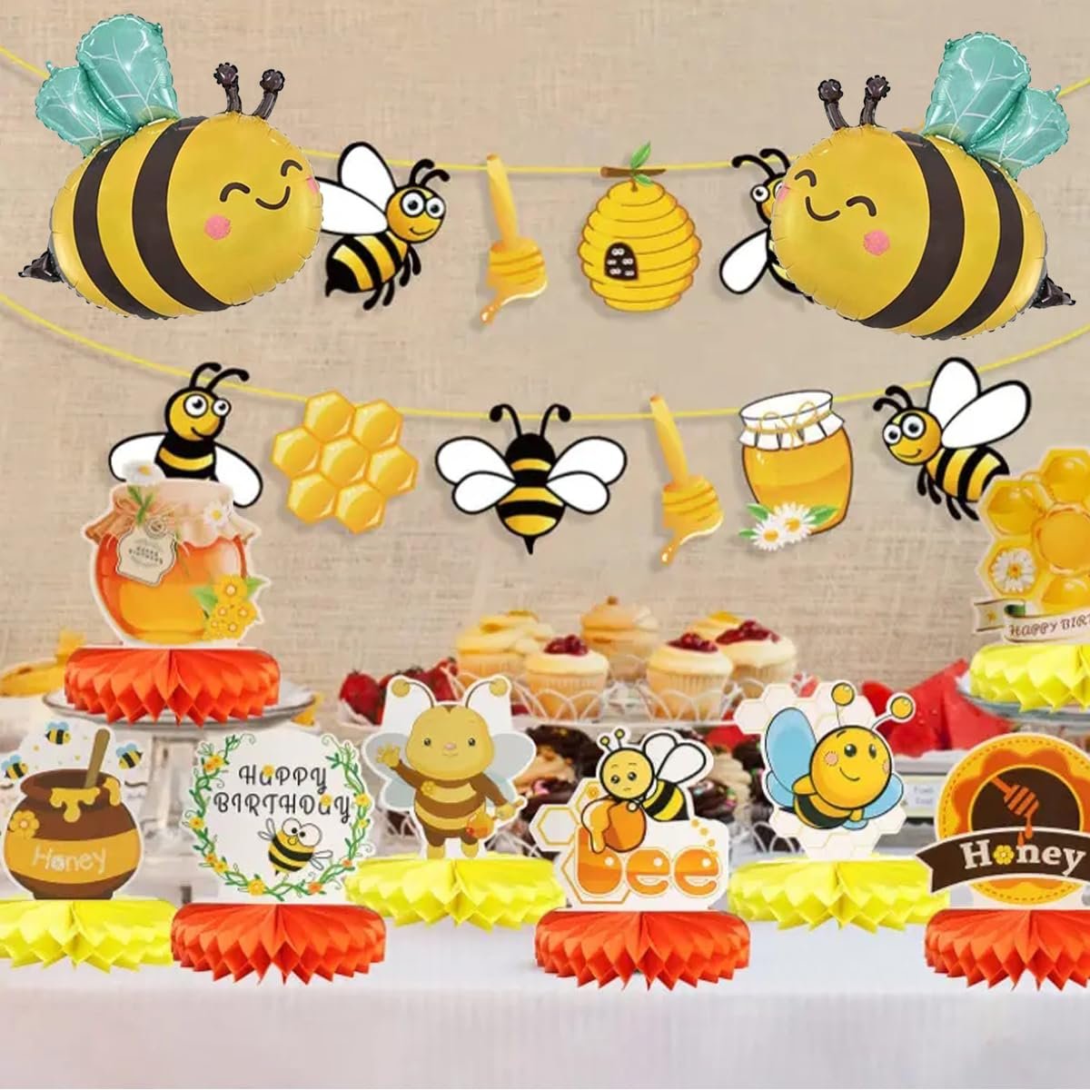 Bee-themed party decorations including balloons, banners, and table centerpieces with honey pots and honeycomb designs.