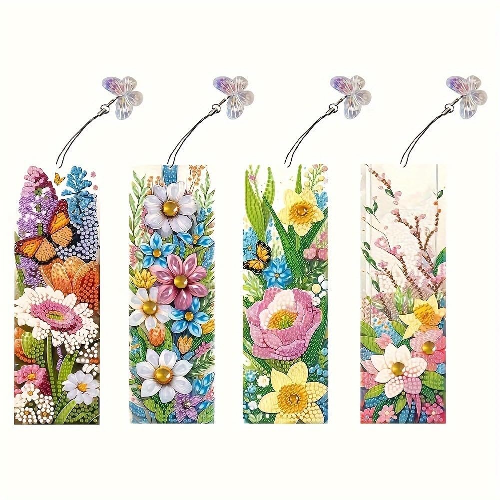 Four diamond art bookmarks with floral and butterfly designs, each with a clear butterfly charm and tassel.