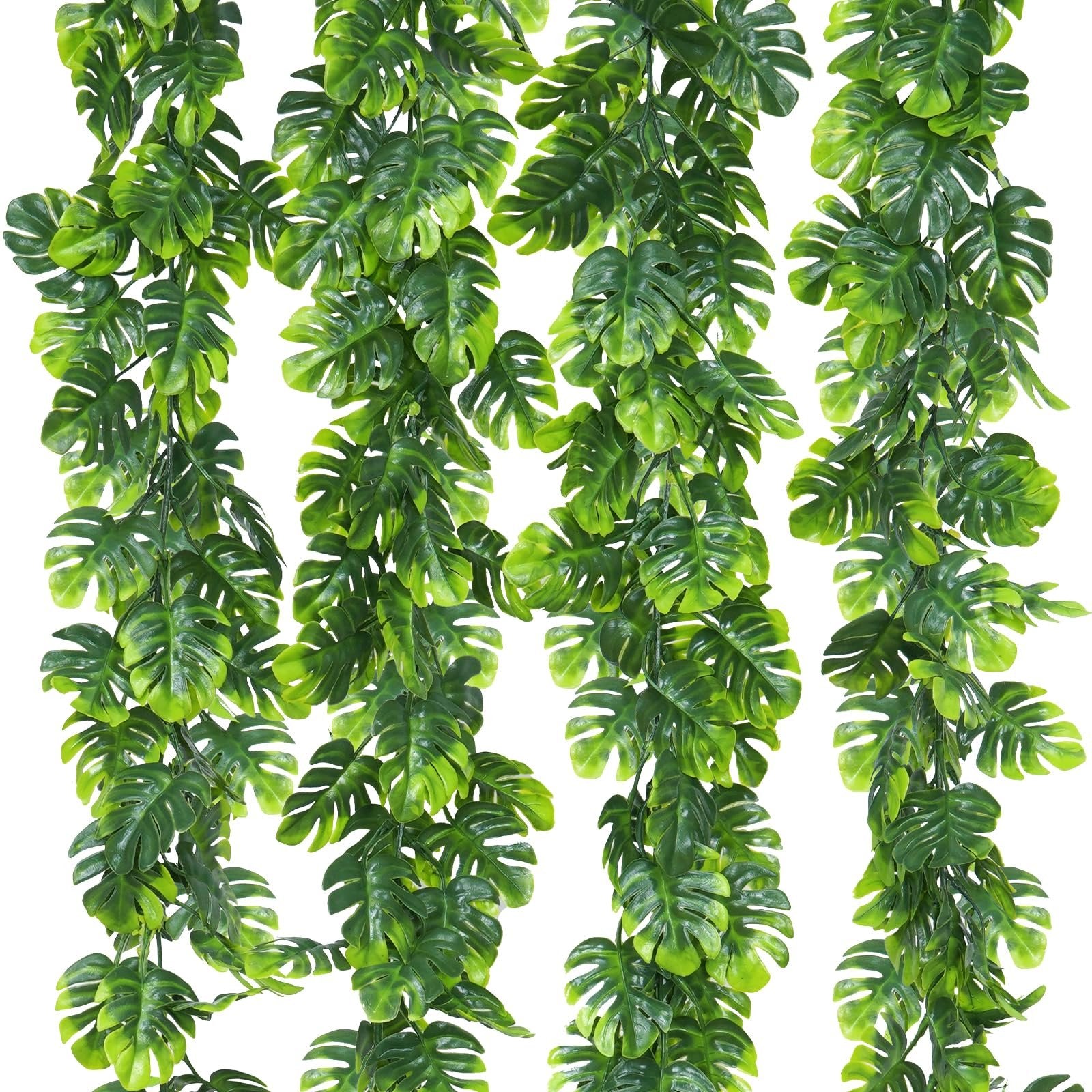 Four artificial monstera leaf vines with green fabric palm leaves and bendable plastic stems against a white background.