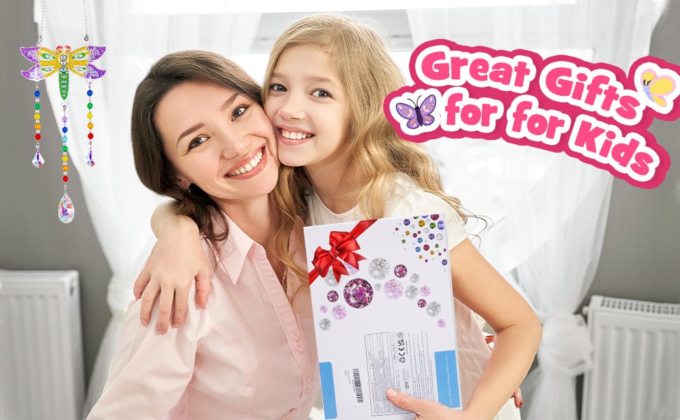 Mother and daughter smiling, holding a diamond painting kit with a dragonfly suncatcher hanging nearby.