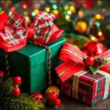Two wrapped Christmas gifts with plaid bows and festive decorations, blurred bokeh lights in background
