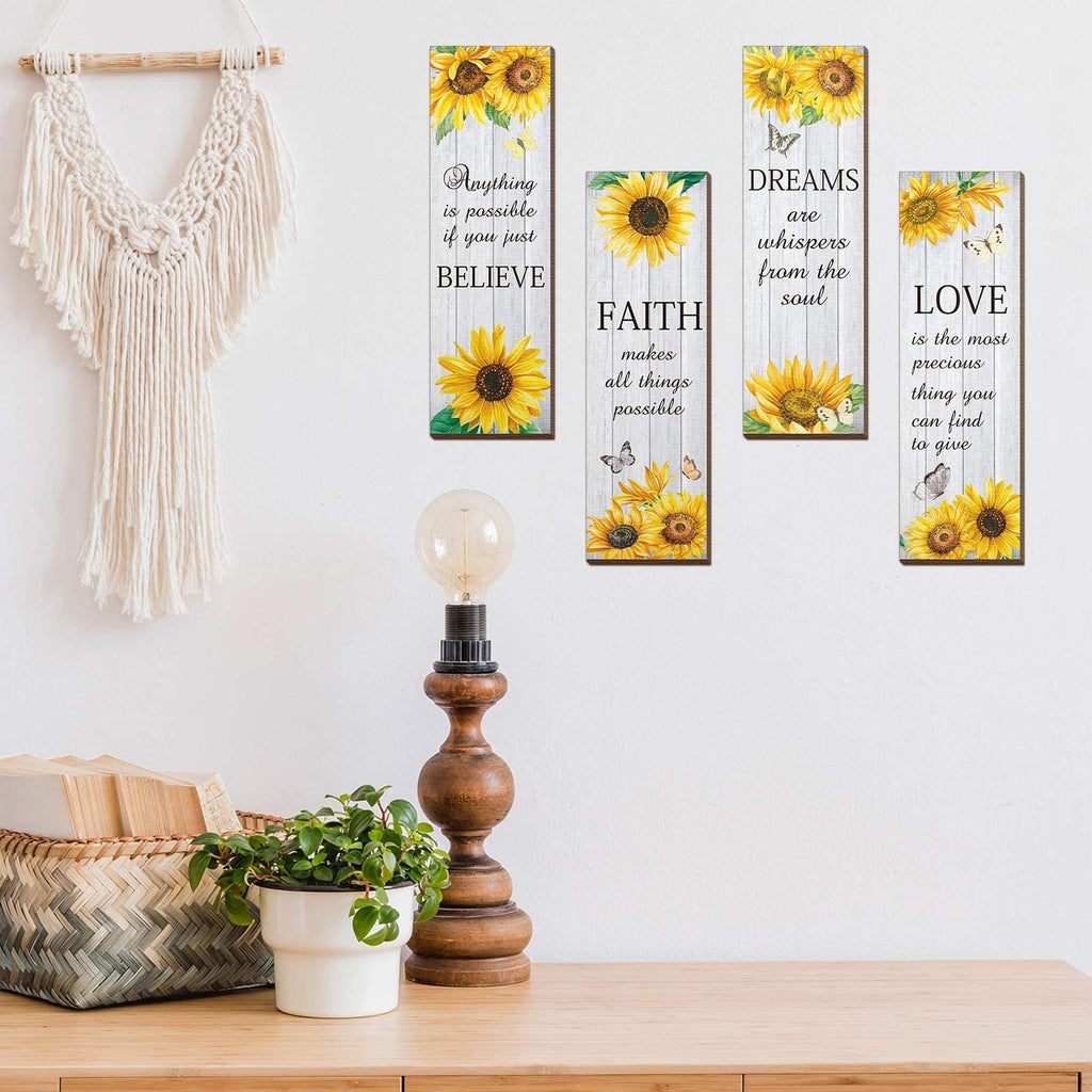 Four vertical wooden wall decor pieces with sunflowers and inspirational quotes, displayed on a wall above a wooden table.