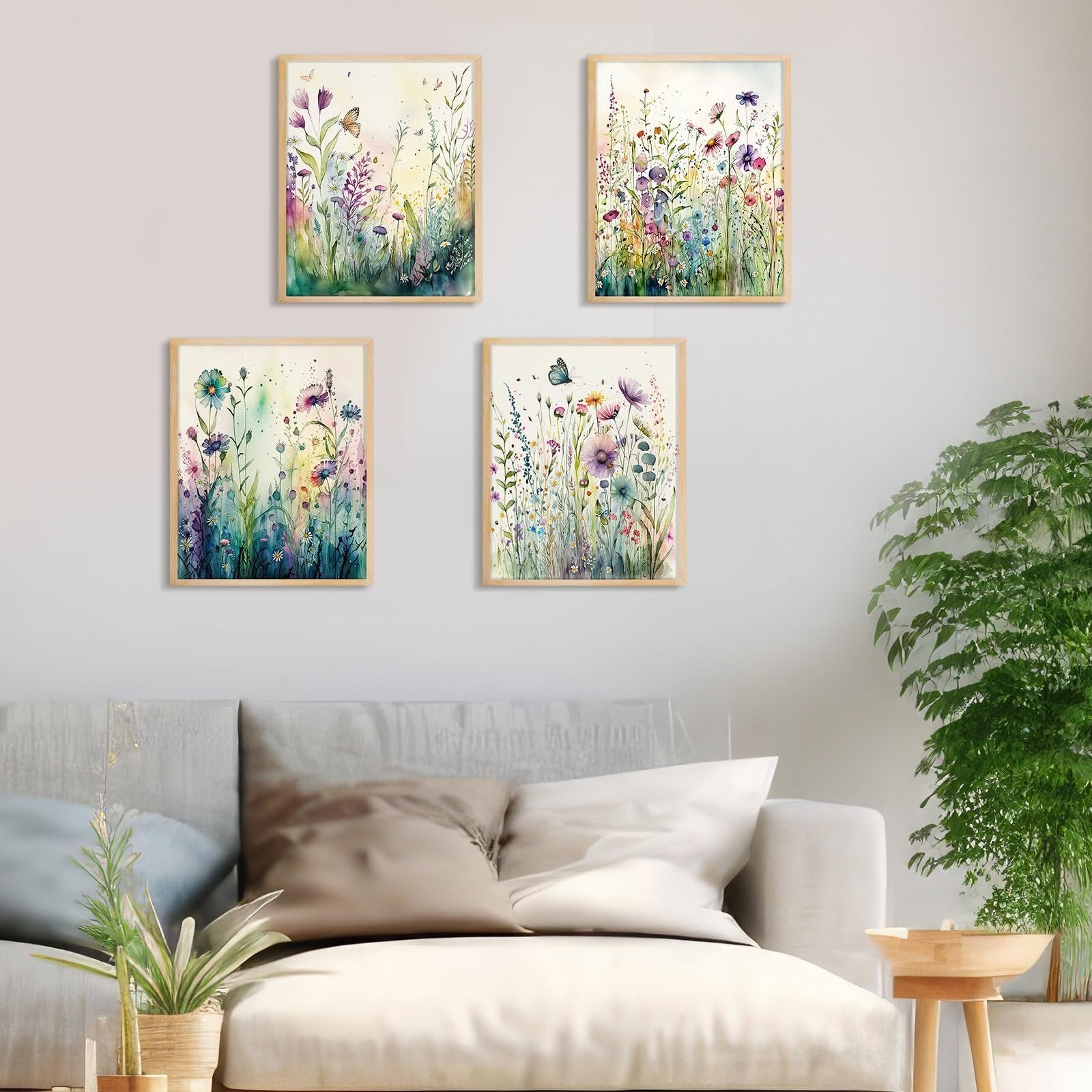 Four framed wildflower diamond art paintings displayed on a wall above a sofa.