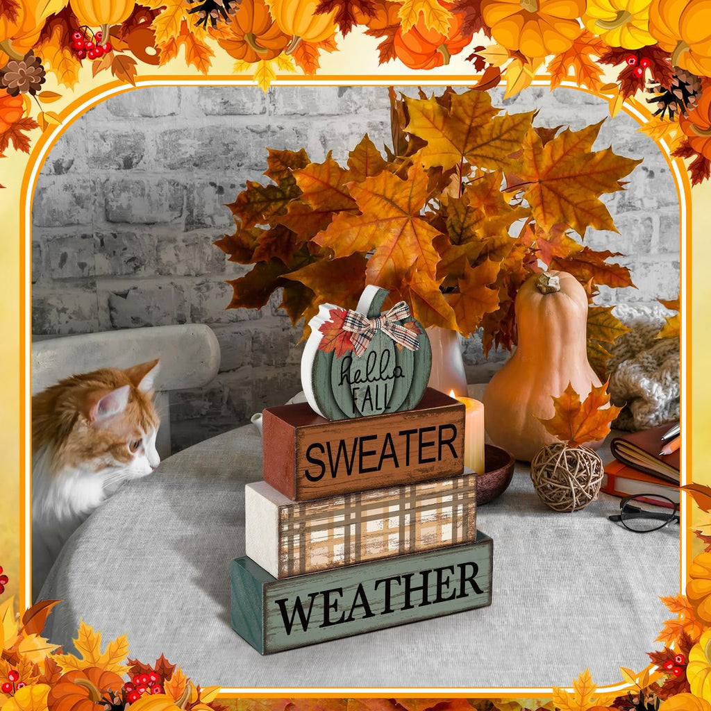 Stack of fall-themed wooden blocks with a pumpkin sign on top, next to a cat and autumn decor.