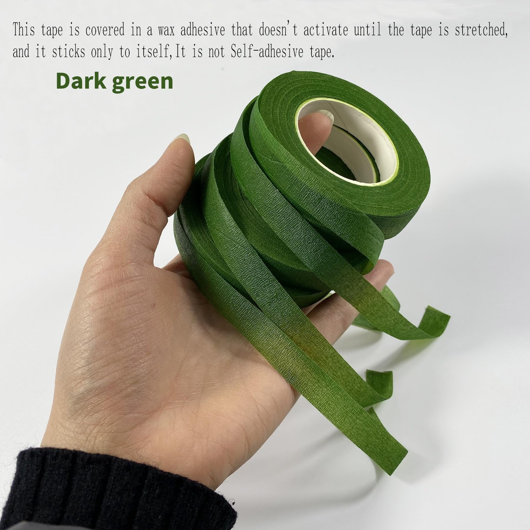 Hand holding dark green floral tape, showing its texture and how it unrolls.