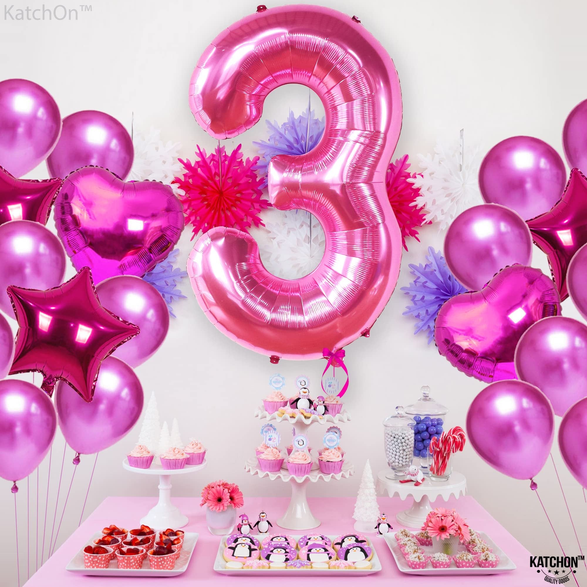 Hot pink number 3 foil balloon with assorted pink balloons and party decorations on a table with cupcakes and cookies.