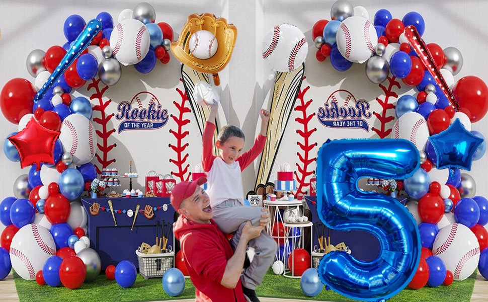 Baseball themed party decorations with a father holding his son, foil balloons, and a 'Rookie of the Year' banner.