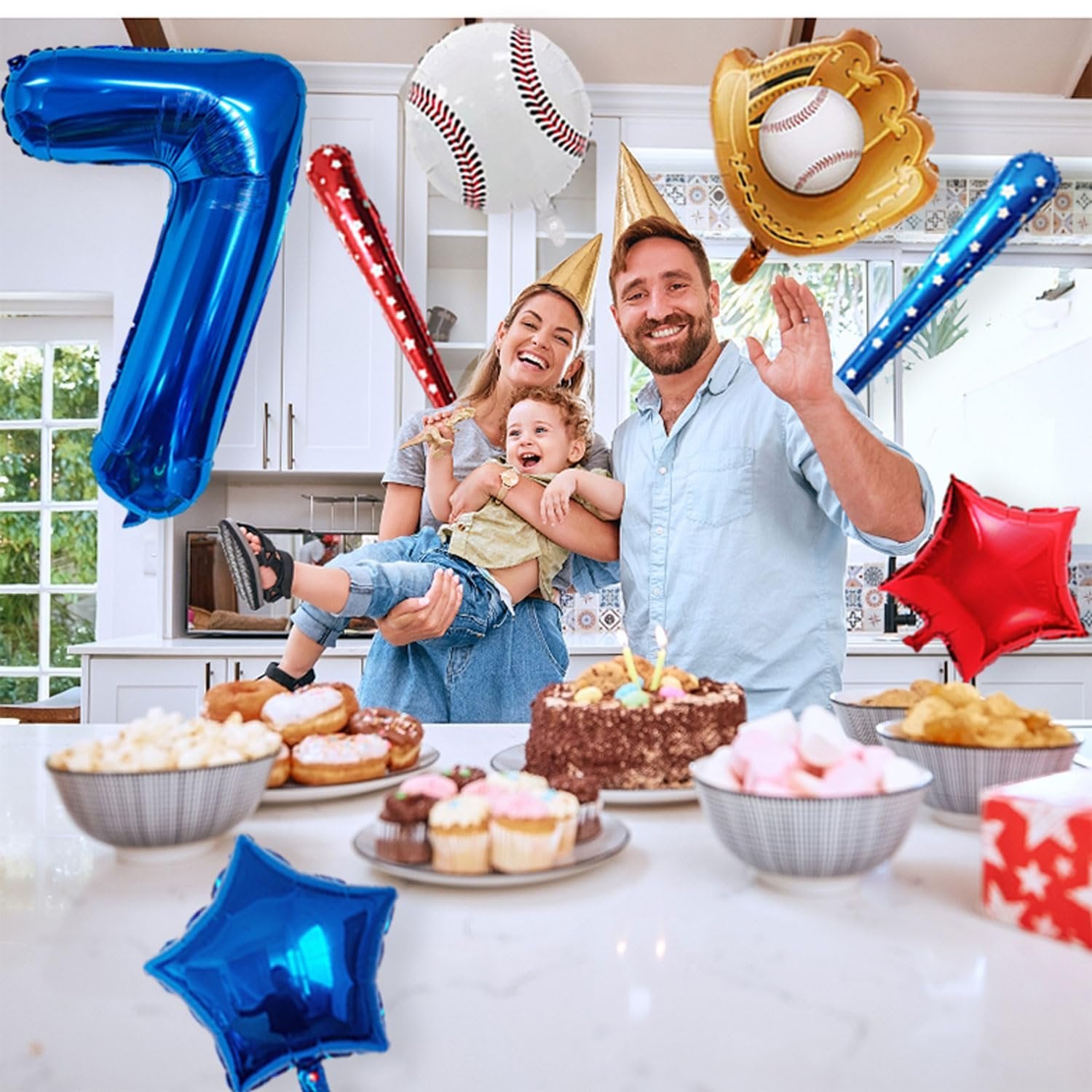 Family celebrating a birthday with baseball-themed balloons and party food on a kitchen counter.