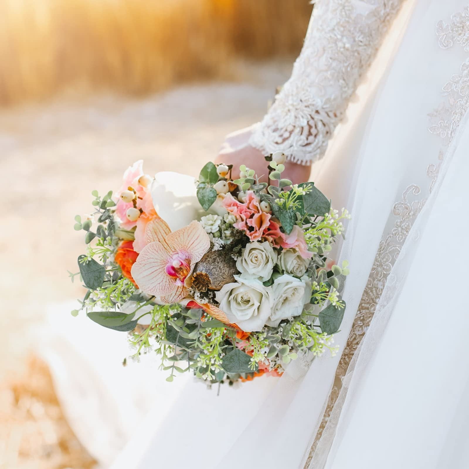 Bride holding a bouquet of artificial flowers including roses, orchids, and eucalyptus leaves.