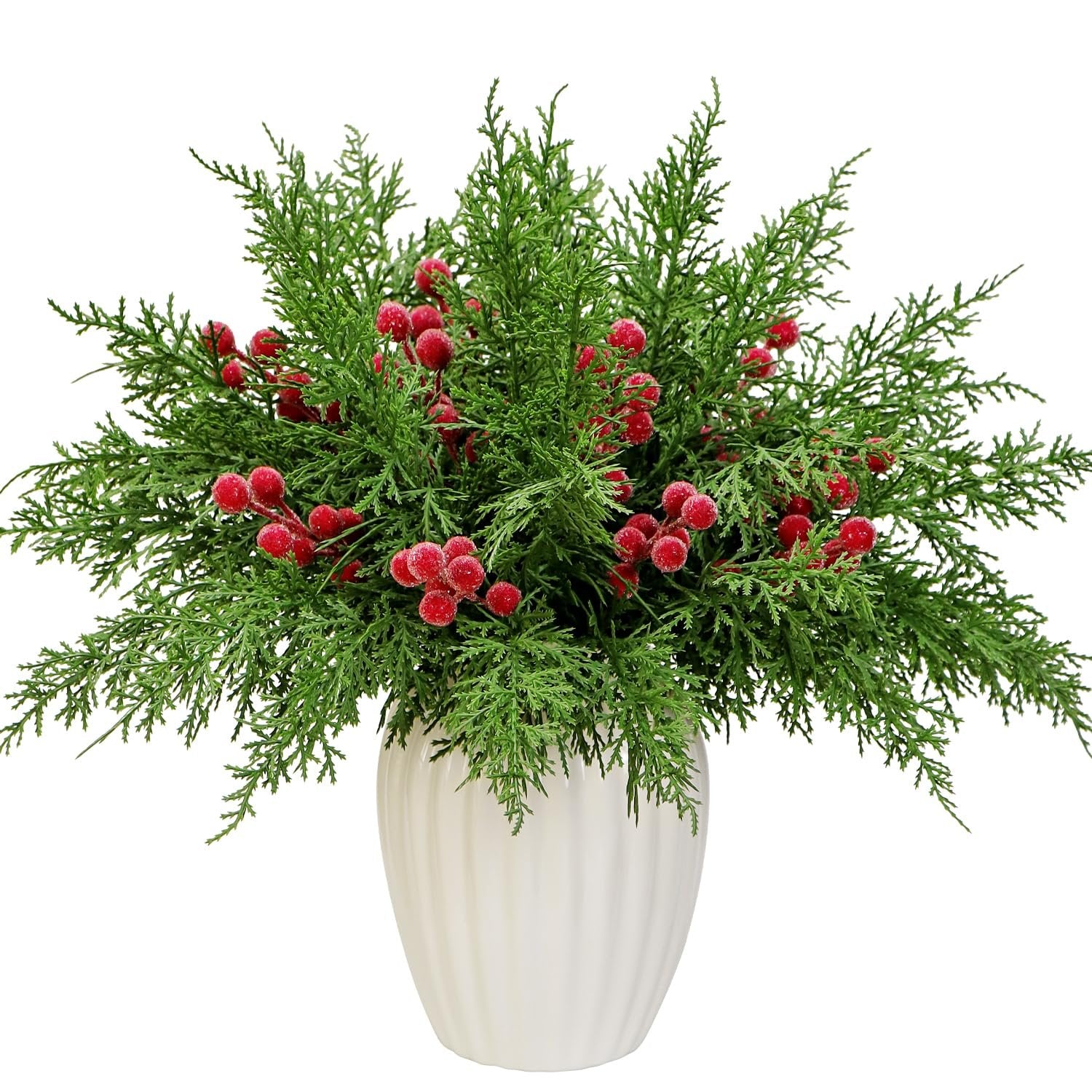 Artificial pine branches with red berries in a white vase, isolated on white background.