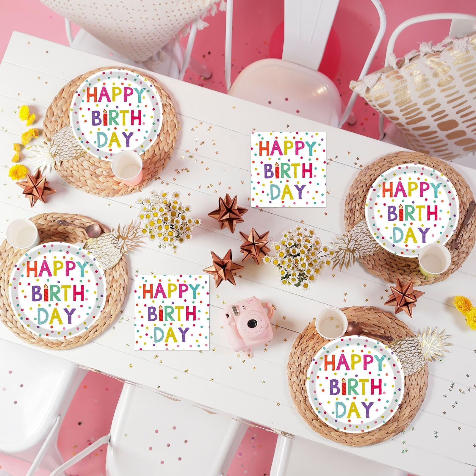 Birthday table setting with four plates and four napkins featuring colorful polka dots and 'Happy Birthday' text, arranged on woven placemats.