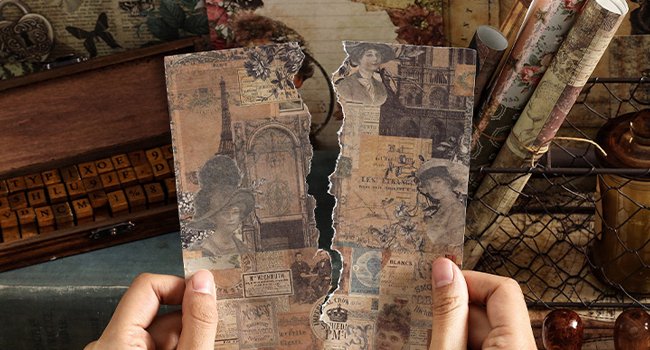 Hands holding torn vintage nature forest ephemera paper with Parisian scenes and portraits