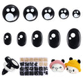 Assortment of black safety eyes in round and oval shapes, with a box of washers and two crocheted amigurumi figures.