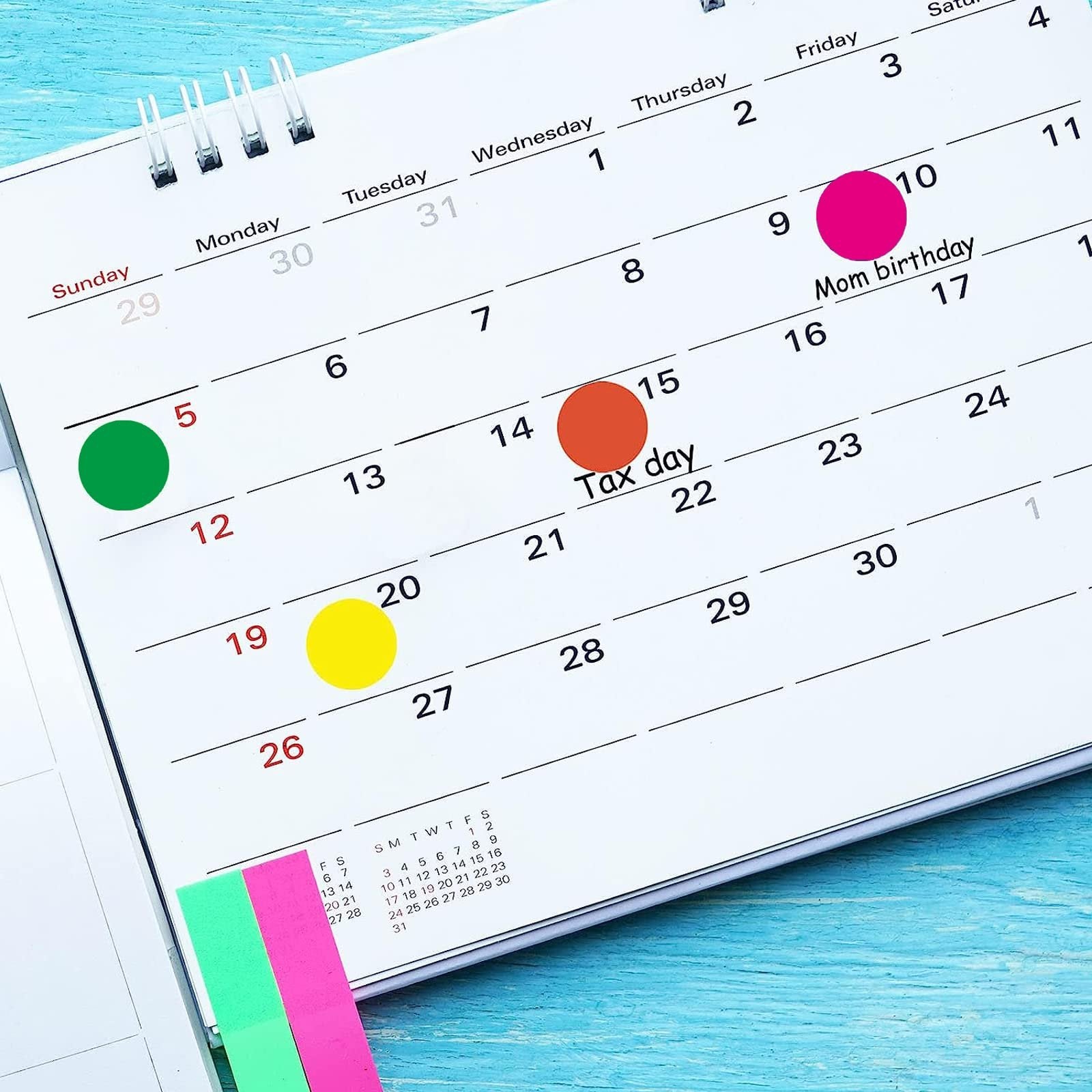Color coding dot stickers applied to a calendar for Tax Day and Mom's birthday.