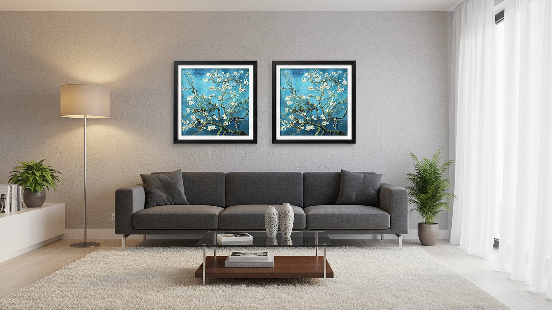Two framed almond blossom paintings hanging above a grey sofa in a living room setting.