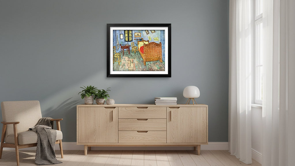 Framed painting of Van Gogh's bedroom displayed on a wall above a wooden credenza with plants and a lamp.