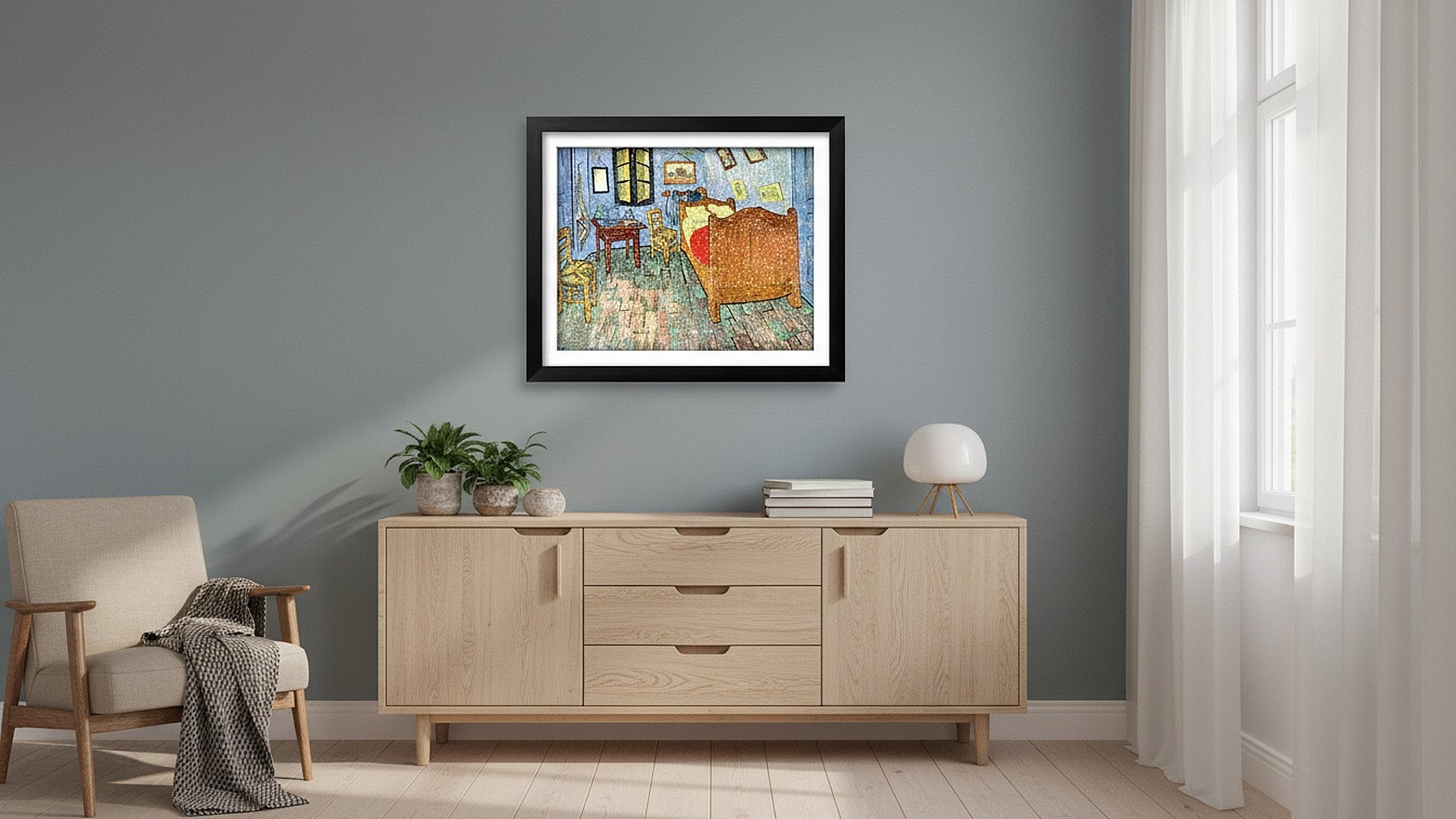 Framed painting of Van Gogh's bedroom displayed on a wall above a wooden credenza with plants and a lamp.